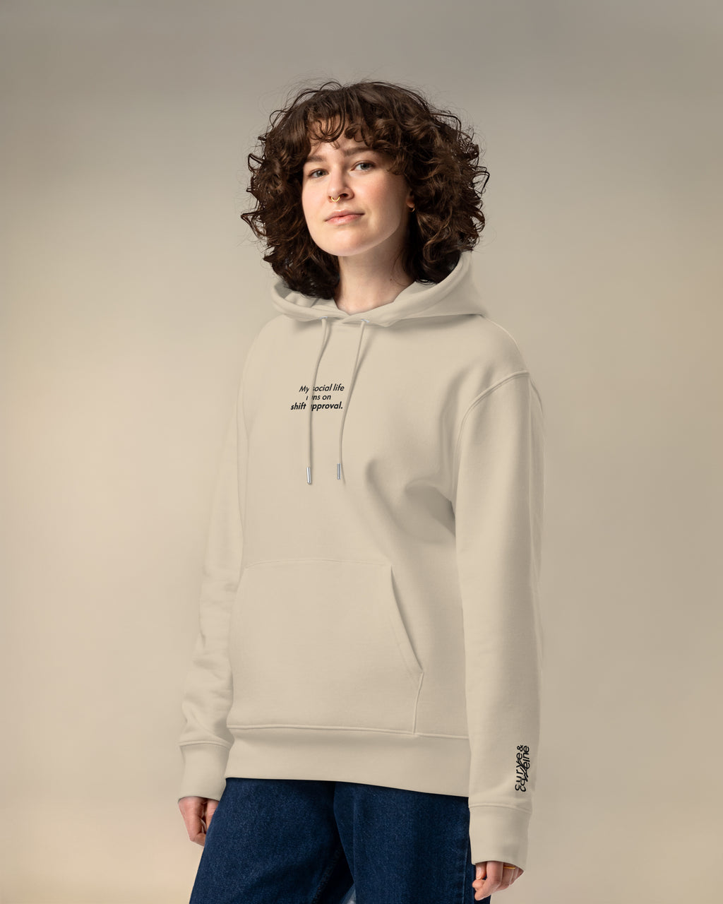 Person wearing a beige hoodie with text on a plain background