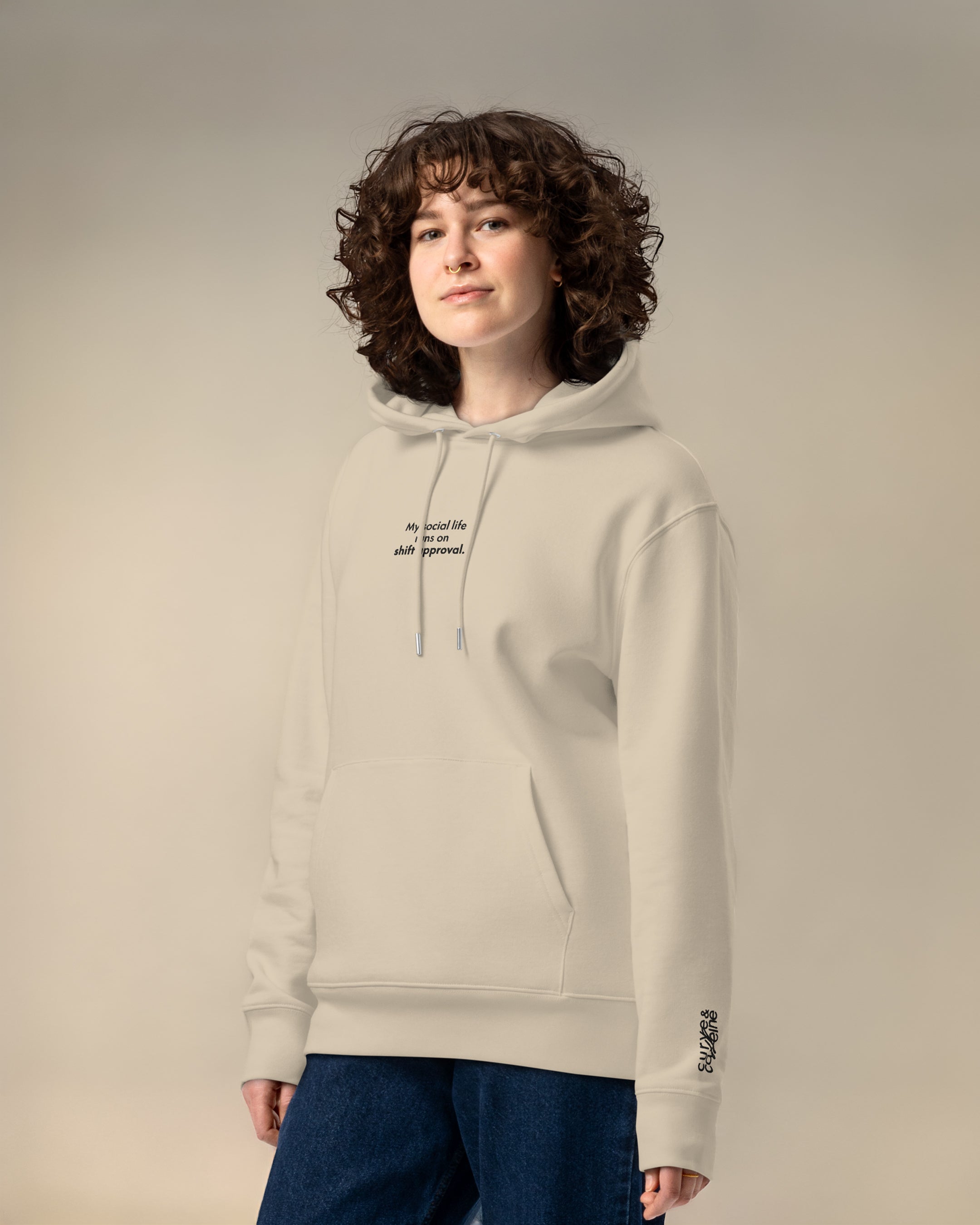 Person wearing a beige hoodie with text on a plain background
