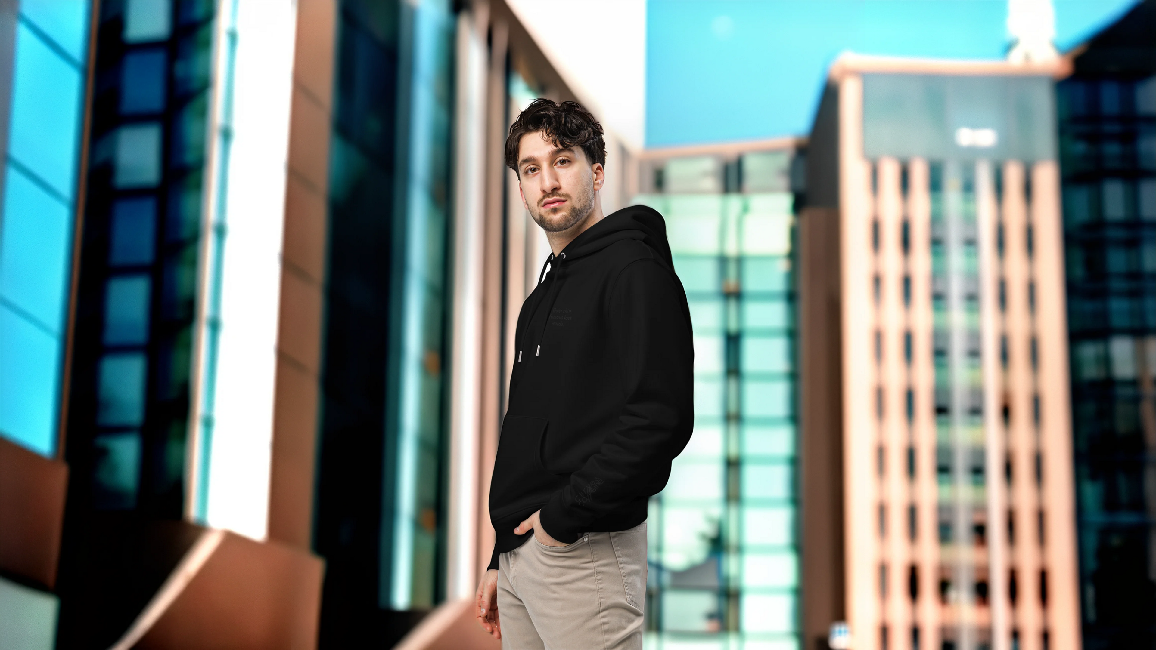 Man standing in front of modern buildings with a blurred background